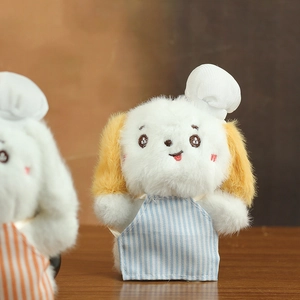 Close-up of plush puppy chef keychain with yellow ears and blue striped apron
