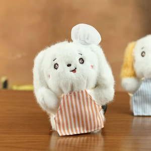 Close-up of cute plush puppy keychain with chef hat and orange striped apron detail