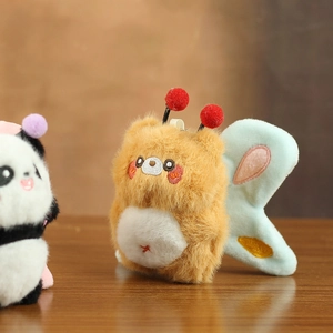 Detail of plush bee and panda keychain charms with embroidery and soft textures