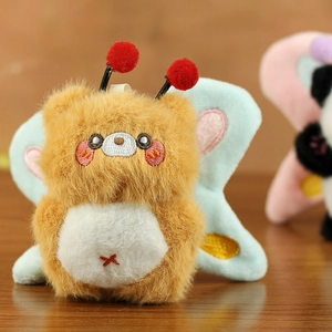 Macro shot of cute plush bear charm with blue wings and soft embroidery details