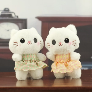 Pair of cute plush white cats wearing lace floral dresses on a warm wooden desk