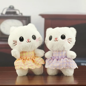 Detailed view of two plush kittens wearing lace plaid dresses with soft fluffy textures