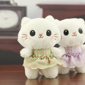 Close-up of white plush kitten toy with fine embroidery and delicate lace dress detail