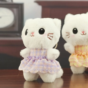 Close-up of white plush cat charm in purple and orange plaid princess dresses