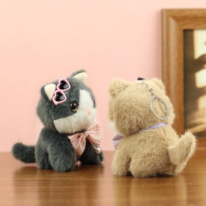 Detail of plush cat charms featuring heart-shaped sunglasses and pearl bowties