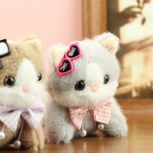 Close-up of fluffy cat plush keychain with cute sunglasses and plaid bow tie details