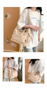 Détail du grand sac cabas en toile beige avec plusieurs poches et étiquette de mode