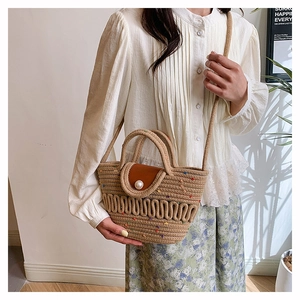 Detail of straw bucket bag with colorful dots, leather flap, and large pearl buckle