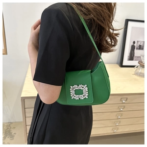 Détail du sac sous l'aisselle en cuir vert vif avec une boucle en cristal étincelante
