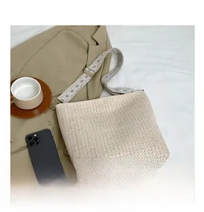 Detail view of woven shoulder bag with geometric pattern wide strap on a blazer