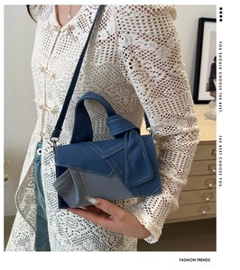 Detail of denim patchwork handbag featuring a decorative knot handle and shoulder strap
