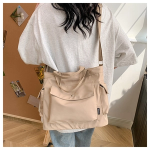 Detail of light beige nylon tote bag with functional pockets and FASHION woven label