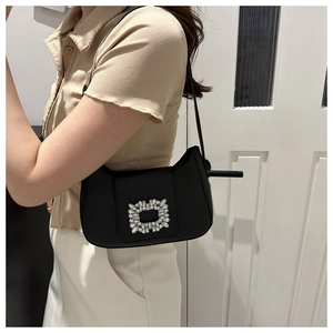 Détail du sac sous le bras en cuir noir avec une boucle carrée luxueuse en strass brillants