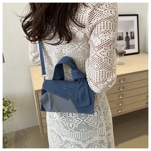 Detail of denim patchwork crossbody bag with knot handle and contrast stitching