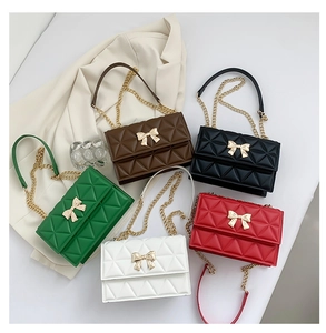 Flat lay of quilted chain shoulder bags with bow metal buckles in five varied colors
