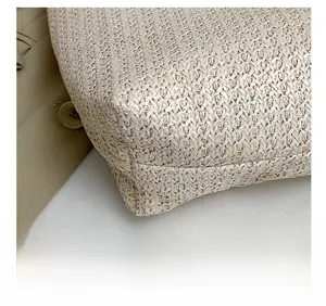 Detailed close-up of woven straw bag showing precision stitching and natural beige texture