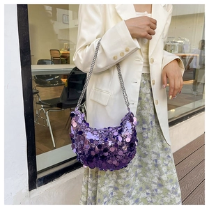 Détail du sac demi-lune à paillettes mauves avec chaîne argentée sur mannequin en blazer