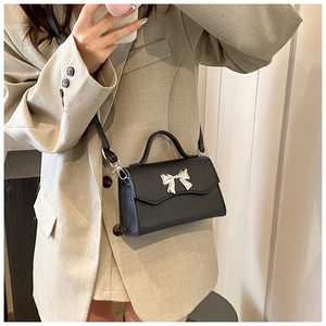 Selfie allo specchio di una mini borsa nera con fiocco argento indossata da una modella
