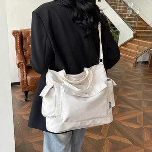 Minimalist white large capacity multi-pocket tote bag shown with shoulder strap