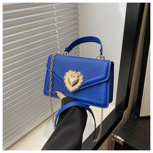 Détail du sac bleu avec boucle cœur baroque dorée et ornements en perles