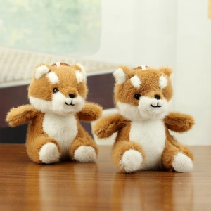 Close-up of cute plush shiba inu dog keychains with soft brown fur on a wooden table