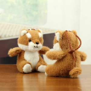 Close-up of soft brown and white plush shiba inu puppy charms with bronze bead chains