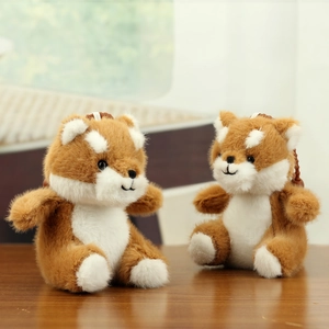 Close-up of cute Shiba Inu plush keychains on a wooden desk with soft home lighting