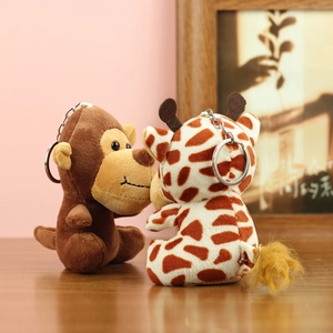 Plüschtier-Schlüsselanhänger Affe und Giraffe mit Metallringen auf einem Holztisch