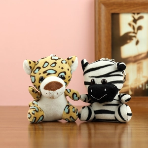 Detail von Plüsch-Leopard und Zebra-Schlüsselanhängern mit Ringen auf Holzboden