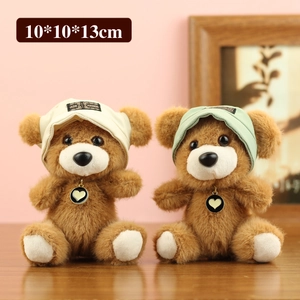 Simpatici orsetti di peluche marroni con cappelli a maglia e ciondoli a cuore eleganti