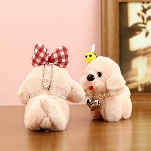 Détail de porte-clés chiots en peluche avec nœuds en dentelle et collier de perles