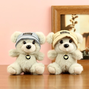Dettaglio di due orsetti di peluche con cappellini handmade e collane a cuore su legno