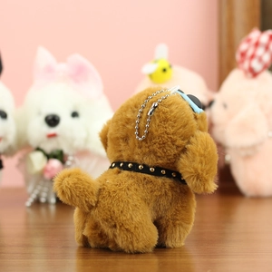 Détail d'un porte-clés chien en peluche marron avec lunettes bleues et collier à clous