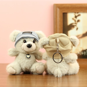 Dettaglio di adorabili portachiavi a forma di orsetto di peluche con cappelli e ciondoli