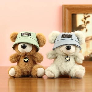 Dettaglio di due orsetti di peluche con cappelli fatti a mano e collane con cuore