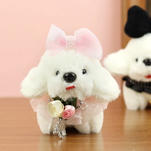 Détail d'un porte-clés chien en peluche blanc avec nœud perlé rose et collier en dentelle