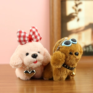 Détail de porte-clés chien en peluche avec nœud, collier à clochette et lunettes de soleil