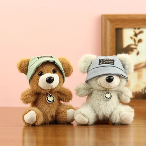 Dettaglio di simpatici orsetti di peluche con cappelli fatti a mano e ciondoli a cuore