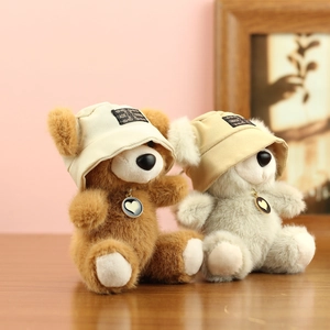 Dettaglio di simpatici orsetti di peluche con mini cappelli e ciondoli a cuore
