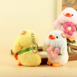 Simpatici portachiavi a forma di anatra di peluche in giallo, bianco e rosa con fiori all'uncinetto