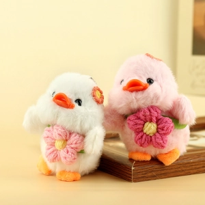 Dettaglio di simpatici anatroccoli di peluche bianchi e rosa con fiori di girasole all'uncinetto