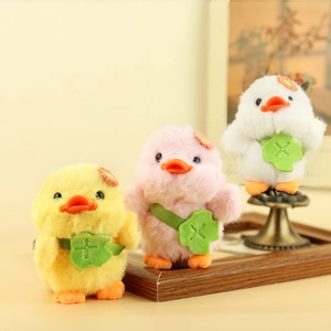Dettaglio di ciondoli a papera in peluche giallo, rosa e bianco con borse a tracolla