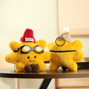 Detailed view of yellow star plush keychain with knit hat and aviator goggles