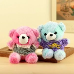 Dettaglio di ciondoli orsetti di peluche con pelliccia colorata e maglioni in maglia