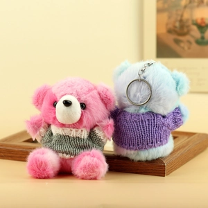 Dettaglio di ciondoli a forma di orsetto rosa e blu con maglioni di maglia e anelli di metallo