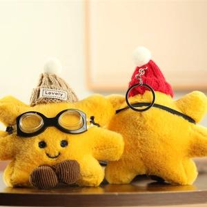 Detail of yellow star plush keychain pendants with knit hats and silver metal clasps