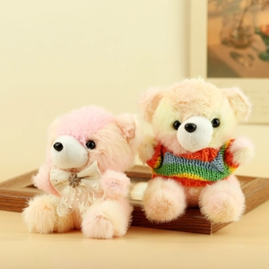 Dettaglio di due orsetti di peluche colorati con fiocco in pizzo e maglione a righe in maglia