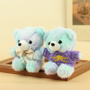 Dettaglio di orsetti di peluche con fiocco in pizzo e maglione viola in maglia fine