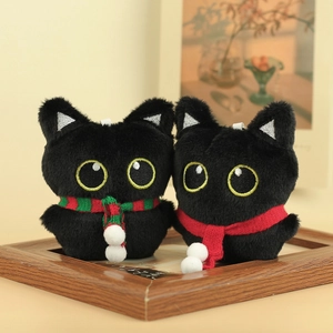 Detail van schattige zwarte pluche kattenhangers met sjaals op houten fotolijst