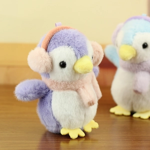 Detailed view of soft plush penguin charms with fluffy earmuffs and warm scarves